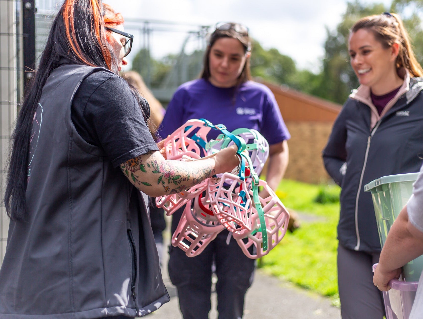 The Muzzle Movement Donating colourful Dog Muzzles with three other people in an outdoor setting