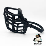 The Muzzle Movement Black Neli dog muzzle with black straps and black hardware with chicago screws on a white background with logo