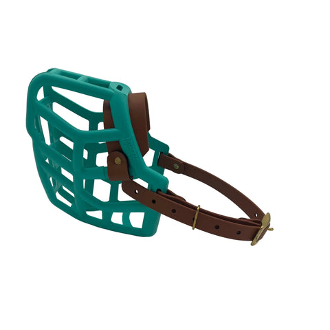 The Muzzle Movement teal dog muzzle with light brown straps and brass hardware on a white background